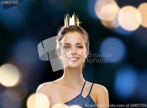 Image of smiling woman in evening dress wearing crown