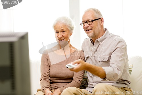 Image of happy senior couple watching tv at home