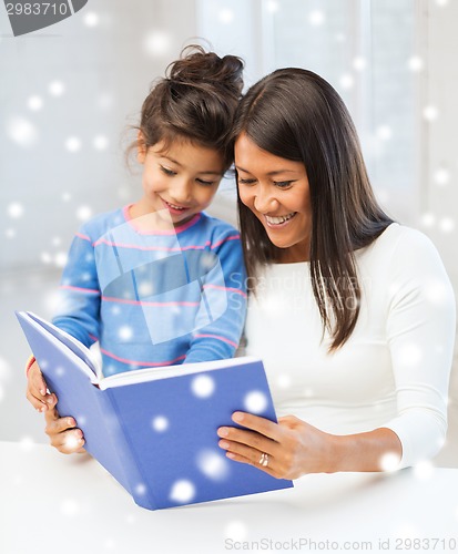 Image of mother and daughter with book indoors