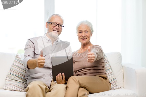 Image of happy senior couple with tablet pc at home