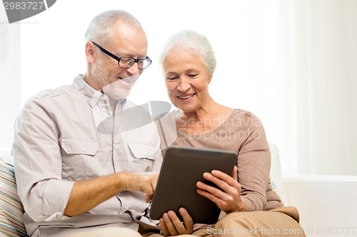 Image of happy senior couple with tablet pc at home