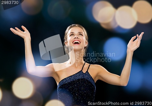 Image of laughing woman rising hands and looking up