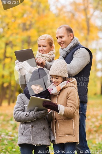 Image of happy family with tablet pc in autumn park