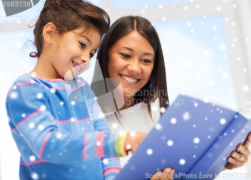 Image of mother and daughter with book indoors