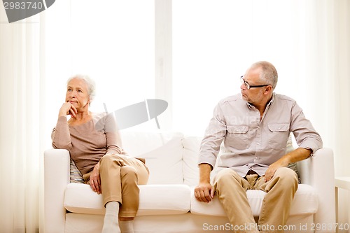 Image of senior couple sitting on sofa at home