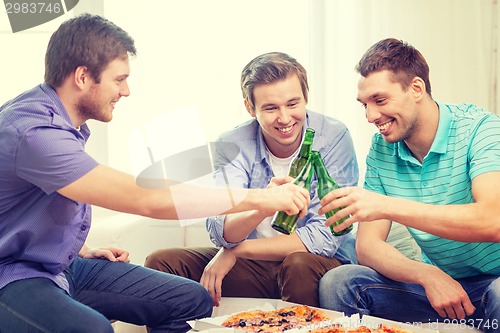 Image of smiling friends with beer and pizza hanging out