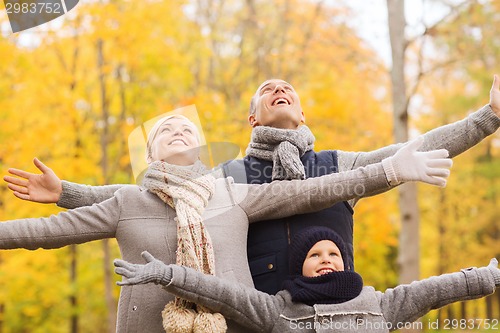 Image of happy family having fun in autumn park