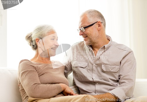 Image of happy senior couple hugging on sofa at home