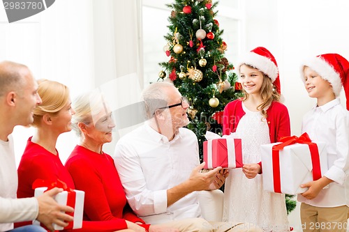 Image of smiling family with gifts at home