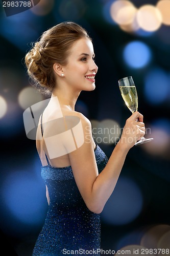 Image of smiling woman holding glass of sparkling wine