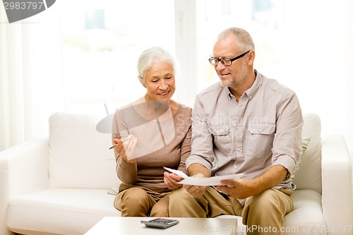 Image of senior couple with papers and calculator at home