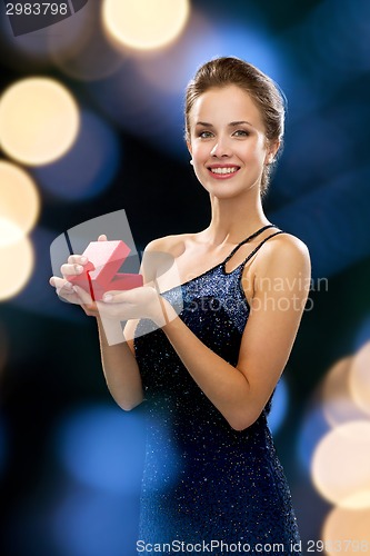 Image of smiling woman holding red gift box