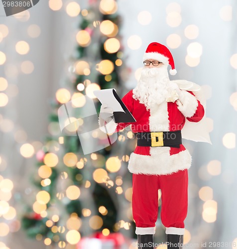 Image of man in costume of santa claus with notepad and bag