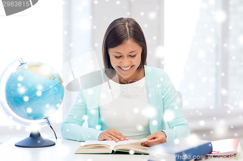 Image of smiling young woman with globe and tablet pc