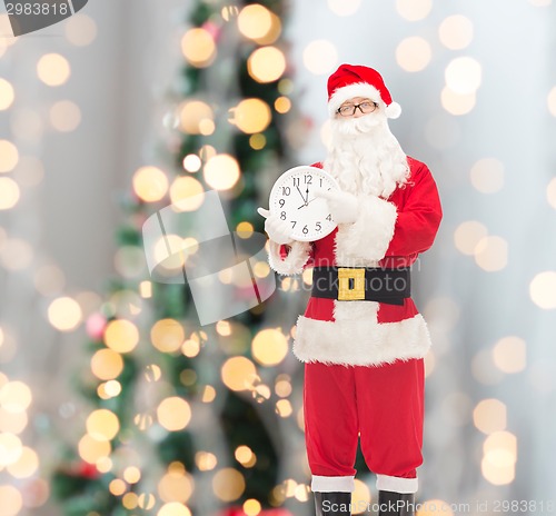 Image of man in costume of santa claus with clock