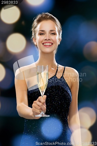 Image of smiling woman holding glass of sparkling wine