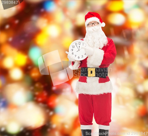 Image of man in costume of santa claus with clock