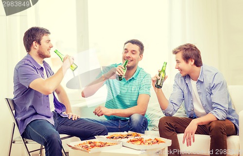 Image of smiling friends with beer and pizza hanging out