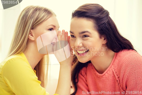 Image of one girl telling another secret