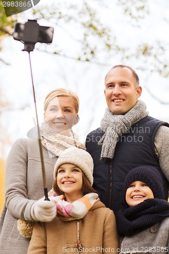 Image of happy family with smartphone and monopod in park