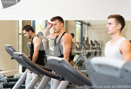 Image of group of men exercising on treadmill in gym