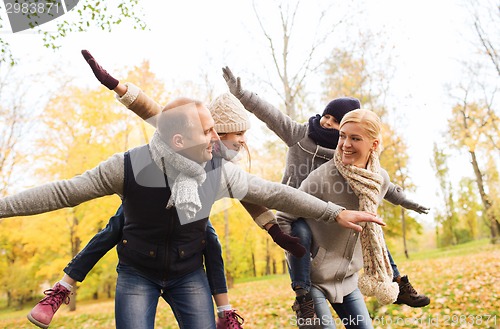 Image of happy family having fun in autumn park