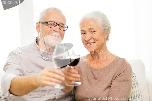 Image of happy senior couple with glasses of red wine