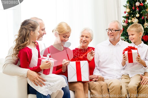 Image of smiling family with gifts at home