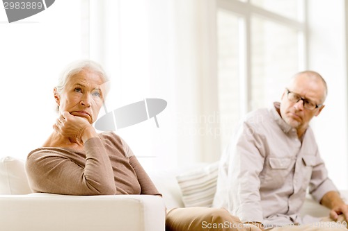 Image of senior couple sitting on sofa at home