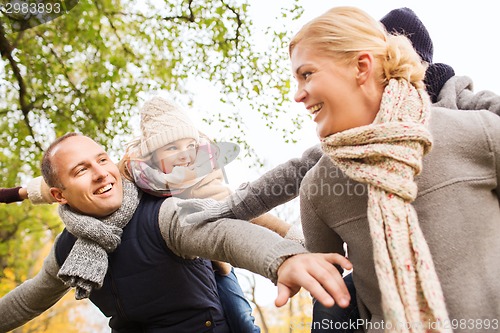 Image of happy family having fun in autumn park