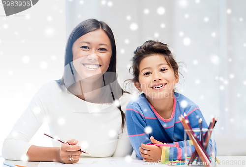 Image of mother and daughter with coloring pencils indoors