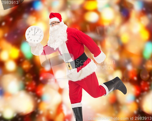 Image of man in costume of santa claus with clock