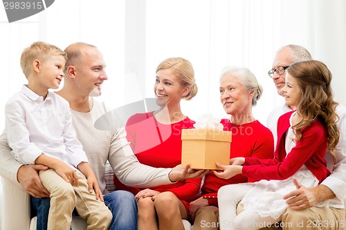 Image of smiling family with gift at home