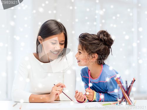 Image of mother and daughter with coloring pencils indoors