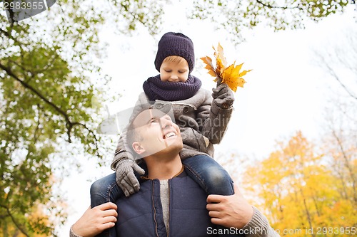 Image of happy family having fun in autumn park