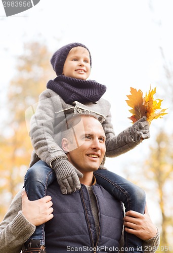 Image of happy family having fun in autumn park