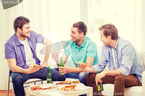 Image of smiling friends with beer and pizza hanging out