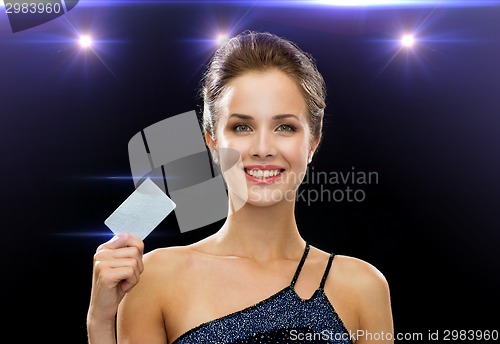 Image of smiling woman in evening dress holding credit card