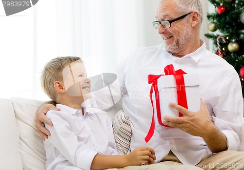 Image of smiling grandfather and grandson at home