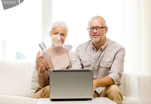 Image of happy senior couple with laptop and credit card