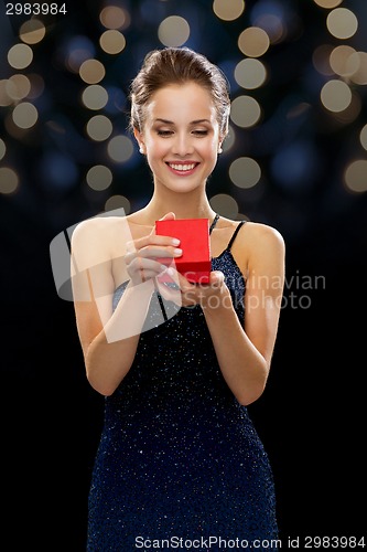 Image of smiling woman holding red gift box