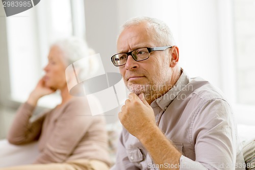 Image of senior couple sitting on sofa at home