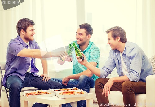 Image of smiling friends with beer and pizza hanging out