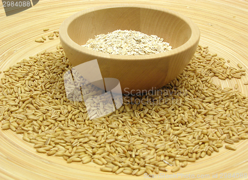 Image of Wooden bowl with oat flakes and corn on bamboo plate