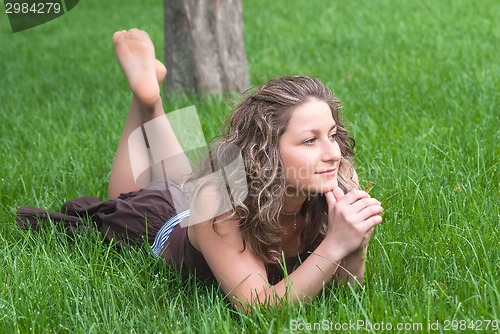 Image of Attractive girl relaxes on grass