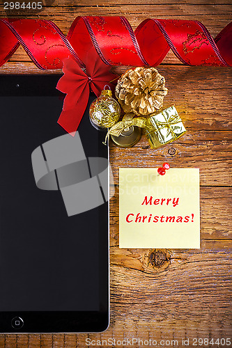 Image of tablet pc with christmas decorations on wooden background