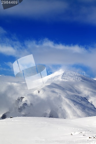 Image of Off-piste slope and blue sky with clouds at sunny day