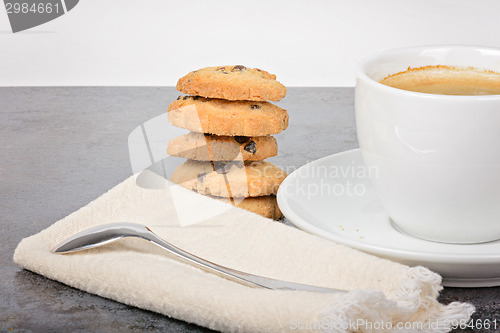 Image of Cup of coffee with cookies and spoon on table