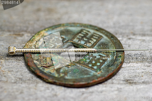 Image of acupuncture needle on antique chinese coin