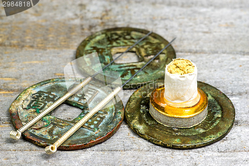 Image of acupuncture needles on antique chinese coin